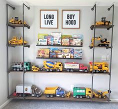 there are many toy trucks on the shelves in this room, and two framed pictures above them