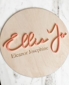 a wooden sign that says ellie jojo on the side of a marble counter top