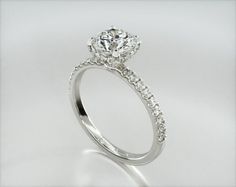 a white gold ring with diamonds on the sides and an oval center stone in the middle