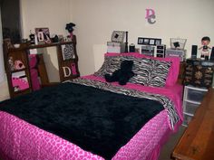 a bedroom with zebra print bedding and pink accents on the walls, black comforter