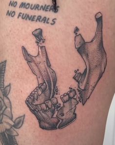 a tattoo on the leg of a person with two hands holding each other and saying no mournrers, no funerals