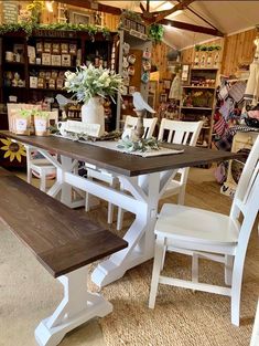 a table and chairs in a store with flowers