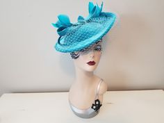 "Vintage Style Aquamarine Blue Velvet Fascinator Hat with Bow & Blusher Veil     12\" wide * 11\" across * 4\" tall Aquamarine blue velvet fascinator hat with matching net blusher veil, dyed to match feathers and whimsical bows on top. Complete with your choice of a matching satin headband or silver alligator clip, both easily slide into an elastic fitting inside. Excellent Condition ~ New, never worn" Adjustable High Crown Blue Costume Hats And Headpieces, Blue Vintage Fascinator For Party, Blue Brimmed Mini Hat For Races, Fitted Blue Brimmed Top Hat, Blue Costume Hats And Headpieces For Church, Blue Brimmed Mini Hats For Royal Ascot, Blue Fitted Fascinator With Curved Brim, Blue Curved Brim Evening Fascinator, Blue Curved Brim Fascinator For Formal Occasions