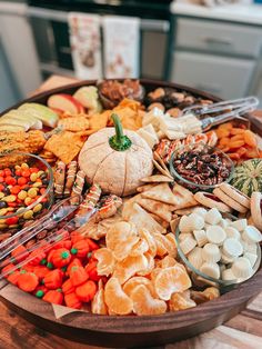 a wooden platter filled with lots of different types of snacks