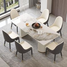 a dining table with chairs around it and a bowl of fruit on the table top