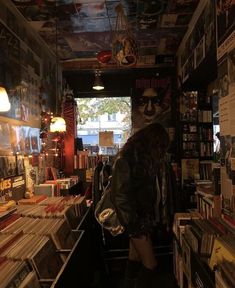 a woman standing in front of a book store filled with lots of books and cds