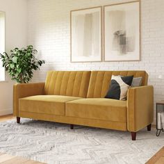 a living room with a couch, rug and two pictures on the wall above it