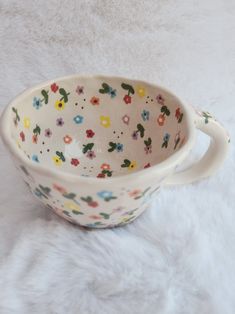 a flowered bowl sitting on top of a white furnishing covered floor next to a wall