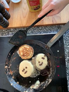 someone is frying pancakes in a pan on the stove top with a spatula