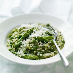 a white bowl filled with rice and asparagus