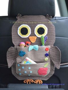 a crocheted owl purse with lots of little toys in it's pocket