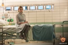 a woman sitting on top of a hospital bed