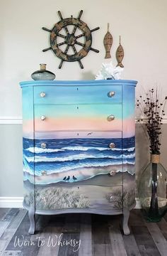 a painted dresser with an ocean scene on it