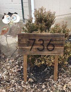 an owl statue is next to a wooden sign that says,'735 '