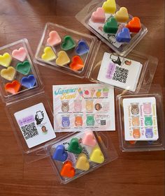 four plastic containers filled with gummy bears sitting on top of a wooden table next to a qr code