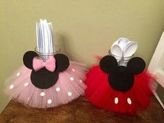 two minnie mouse tutu skirts are sitting on a table with utensils in them