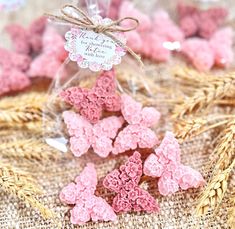 small pink flowers are in a bag on the table next to some ears of wheat