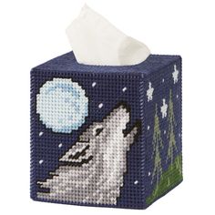 a blue tissue box with a white wolf on it's front and night sky in the background