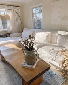 a living room filled with furniture and a wooden table in front of a white couch