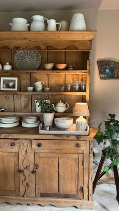 an old wooden cabinet with dishes on it