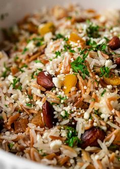 a bowl filled with rice, nuts and parsley on top of other food items