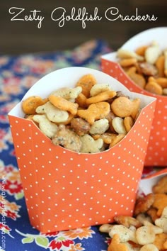 two orange boxes filled with snacks on top of a table