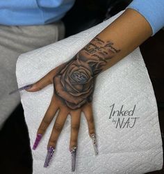 a woman's hand with a rose tattooed on the middle of her left arm