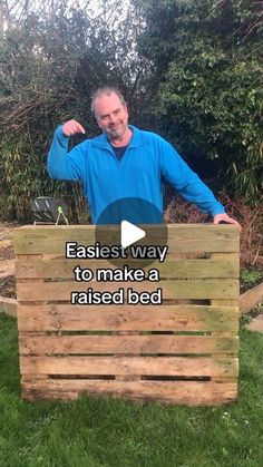 a man standing next to a wooden box with the words easier way to make a raised bed