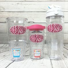 three personalized tumblers sitting next to each other on a white table with wood planks