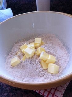 a bowl filled with flour and cubes of butter