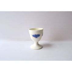 a small white cup with blue flowers on it