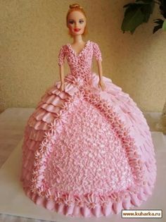 a cake that looks like a barbie doll in a pink dress with ruffles on it