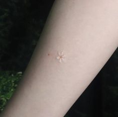 a person with a small flower on their left arm and the other side of her arm