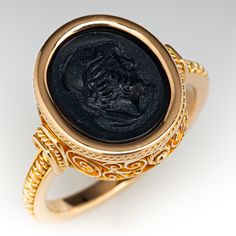 This detailed 18k yellow gold ring holds an onyx intaglio and had a nice wearable low profile design. The ring is currently size 9 and the band has a continuous rope design all the way around that may be interrupted if resized. Luxury 14k Gold Signet Ring With Intaglio, Carved 14k Gold Signet Ring For Formal Occasions, Formal Carved Signet Ring In 14k Gold, Carved Signet Ring In 14k Gold For Formal Occasions, Formal Oval Engraved Ring With Intaglio, Oval Engraved Ring With Intaglio For Formal Events, Classic Carved Signet Ring For Formal Occasions, Luxury Formal Signet Ring With Intaglio, Formal Carved Yellow Gold Signet Ring