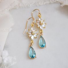 "Flower Earrings // Whimsical Wedding //  Boho Bridal Earrings // Blue Teardrop Earrings // Bridesmaids Gift // Floral Earrings These beautiful whimsical wedding earrings are created with a unique cubic zirconia floral design. Adorned to the flower earrings are faceted light blue teardrops set inside of golden bezels. The flower earrings are secured to dainty 14k gold filled earring wires for a comfortable all day wear. Whether searching for boho bridal earrings for your bridesmaids or unique fl Light Blue Jewelry, Light Green Earrings, Boho Bridal Earrings, Light Blue Earrings, Blue Bridal Earrings, Handmade Wedding Jewellery, Boho Bridal Jewelry, Gold Flower Earrings, Classy Earrings