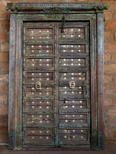 an old wooden door with metal knobs on it