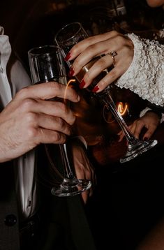 two people holding wine glasses in their hands