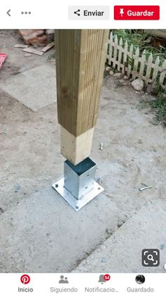 a wooden post with a metal base on the ground