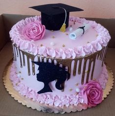 a decorated cake in the shape of a graduation cap and gown with pink flowers on top