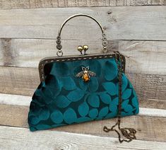 Stunning, handmade, dark teal green embossed velvet clutch bag with cotton lining. Use it as a classic clutch or attach the shoulder strap to wear over your shoulder or as a crossbody. - H:19cm x W:29cm x D:4cm approximately  - Bronze colour chain strap (detachable) - Bronze colour metal clasp: H:6.5cm x W:20cm - Top handle: H:8.5cm (Not detachable) - Tiger eye stone detail (The markings on the stone may be slightly different) The pattern of the lining inside of the bag may vary. But don't worry Green Clutch Evening Bag With Detachable Handle, Elegant Green Evening Bag With Top Carry Handle, Elegant Green Evening Bag With Top Handle, Velvet Clutch Bag, Embossed Velvet, Bronze Colour, Velvet Clutch, Vintage Handbag, Tiger Eye Stone