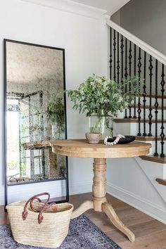 a wooden table sitting on top of a rug next to a banister and stairs