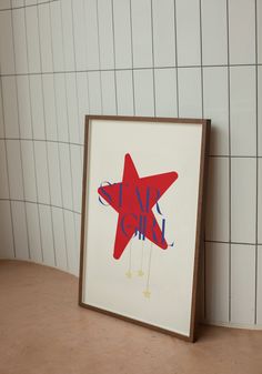 a red and blue star on a white tiled wall next to a framed photograph with the words live laugh