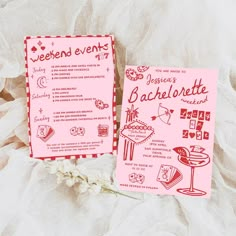 two pink menus sitting next to each other on a white cloth covered tablecloth