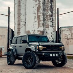 a gray truck parked in front of a large silo