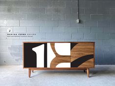 the sideboard is made from wood and has black, white and brown designs on it