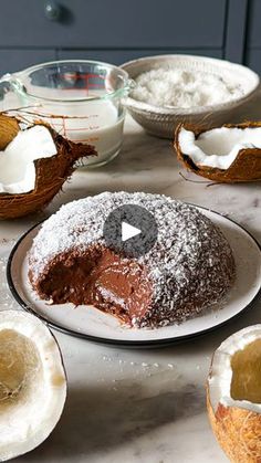 a table topped with coconuts and cakes covered in powdered sugar