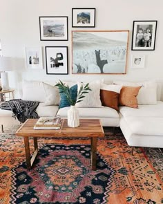 a living room filled with lots of furniture and pictures on the wall above it's coffee table