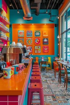 the interior of a brightly colored restaurant with colorful tables and chairs in front of large windows