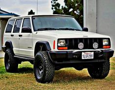 a white jeep parked in front of a house