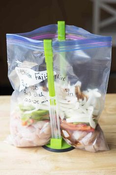 a plastic bag filled with food sitting on top of a wooden table